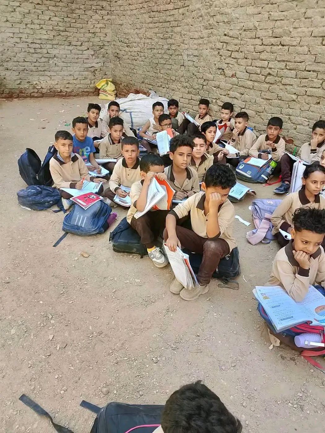 جلوس تلاميذ على الأرض بمدرسة العدلية