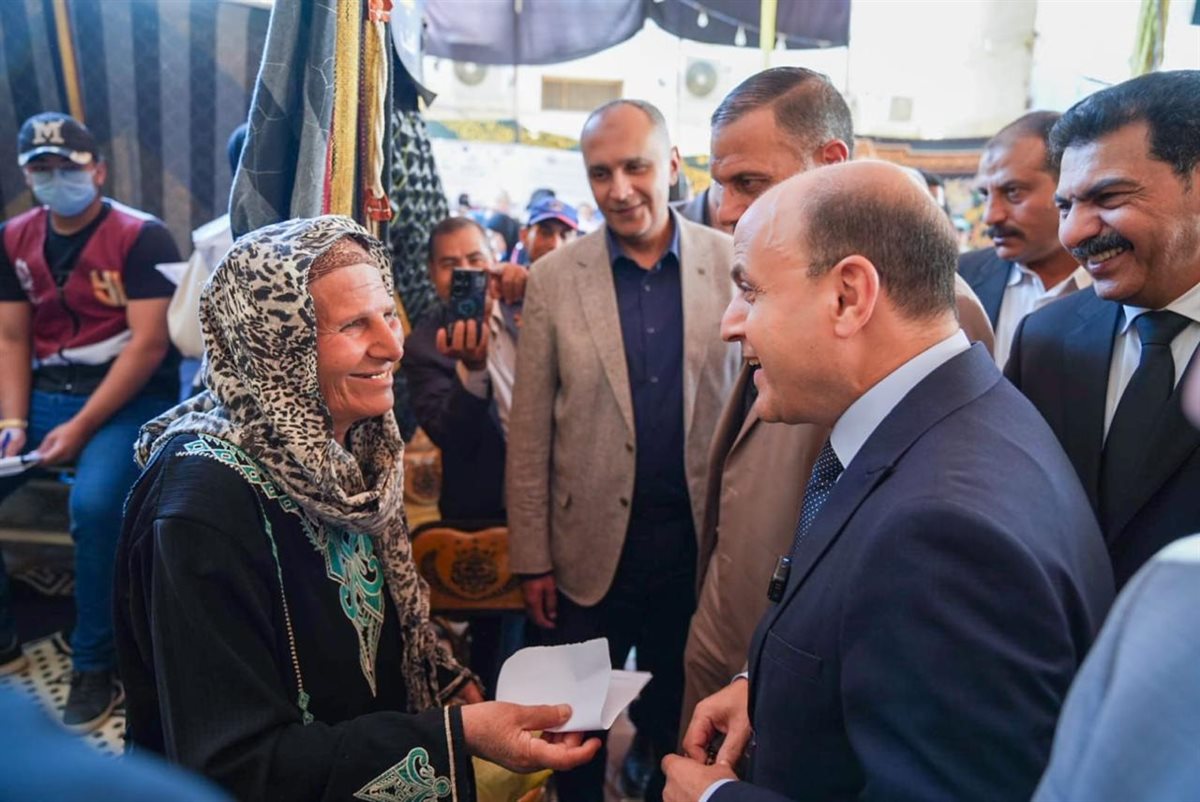 ياسر الحفناوي أثناء تحدثه مع أحد المواطنين المستفيدين من قافلة صحتكم أمانة
