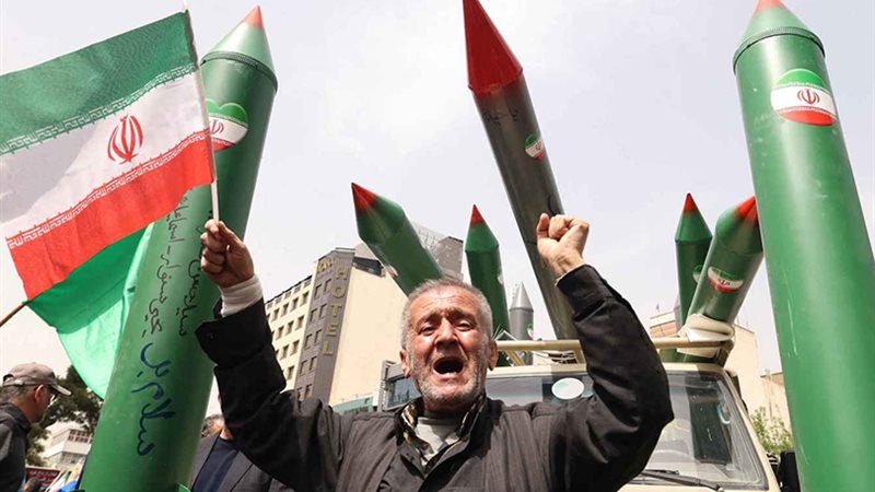 رجل يرفع العلم الإيراني